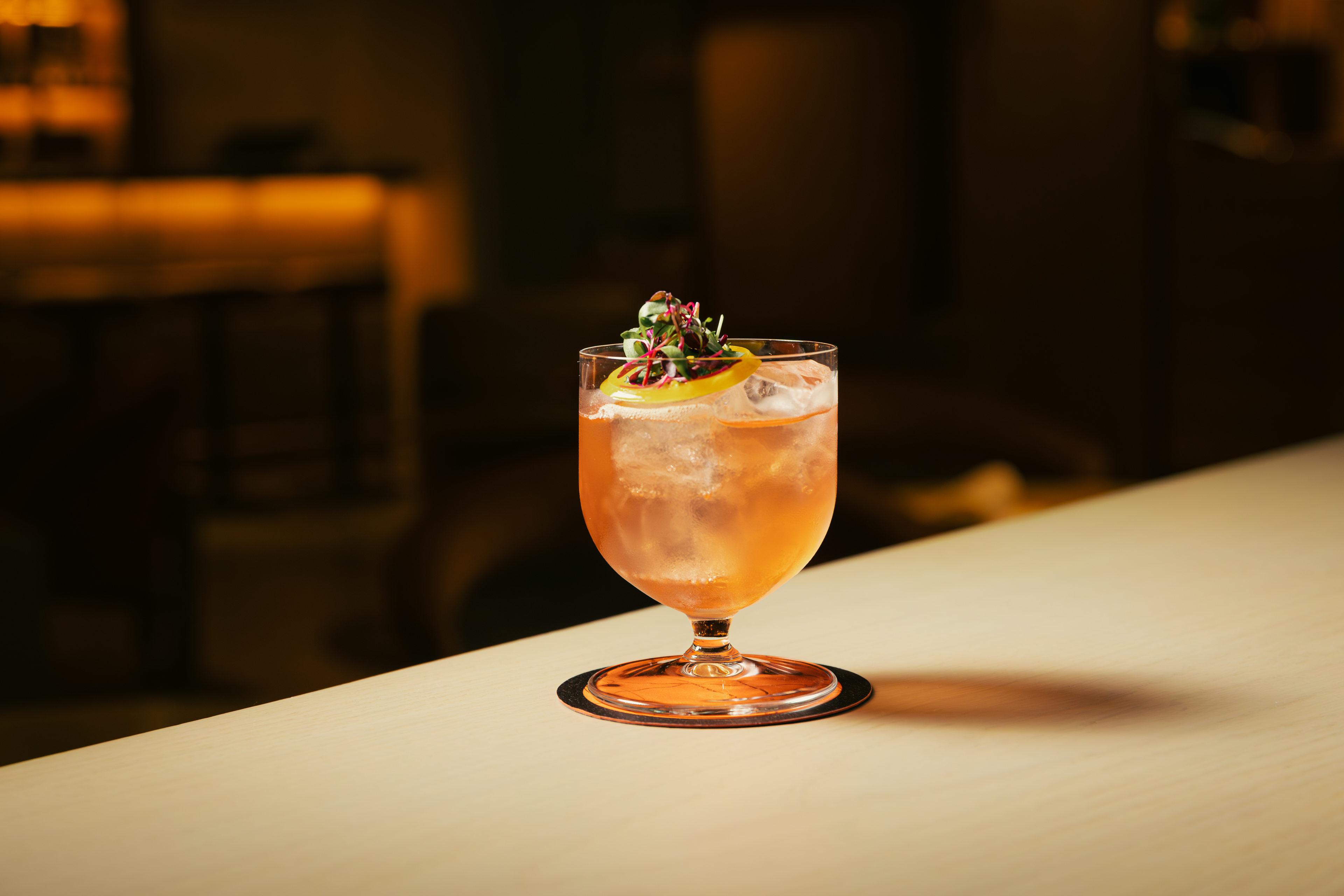 Elegant hand rolled spritz cocktail in coupe glass with citrus garnish at Seed Library Shoreditch, a cocktail bar in London.